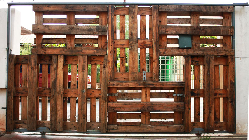 Puerta de acceso a la parcela conformada con palets